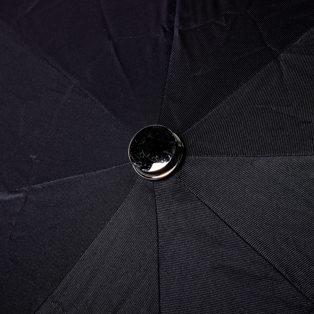 A Black Alligator Travel Umbrella with Black Canopy from KirbyAllison.com in close up with a button on it.