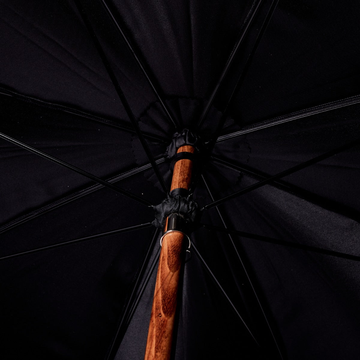 A close up of a handcrafted KirbyAllison.com Black Canopy Umbrella with Malacca Handle.