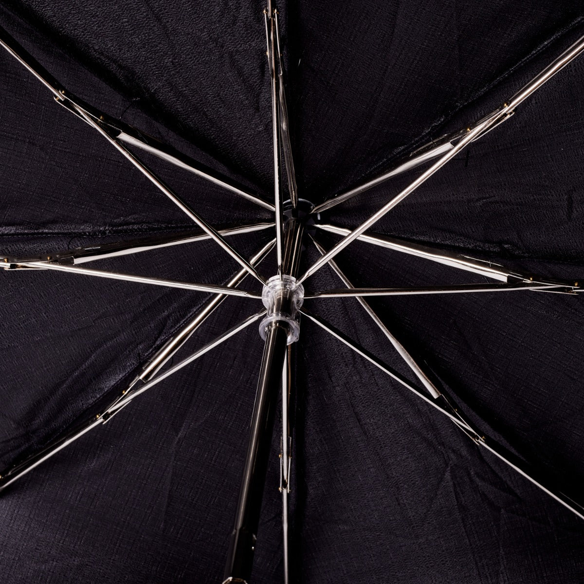 A close up of a KirbyAllison.com Black Pigskin Travel Umbrella with Black Canopy.