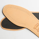 A pair of KirbyAllison.com Saphir Leather Insoles with odor-absorbent charcoal bottom on a white surface.