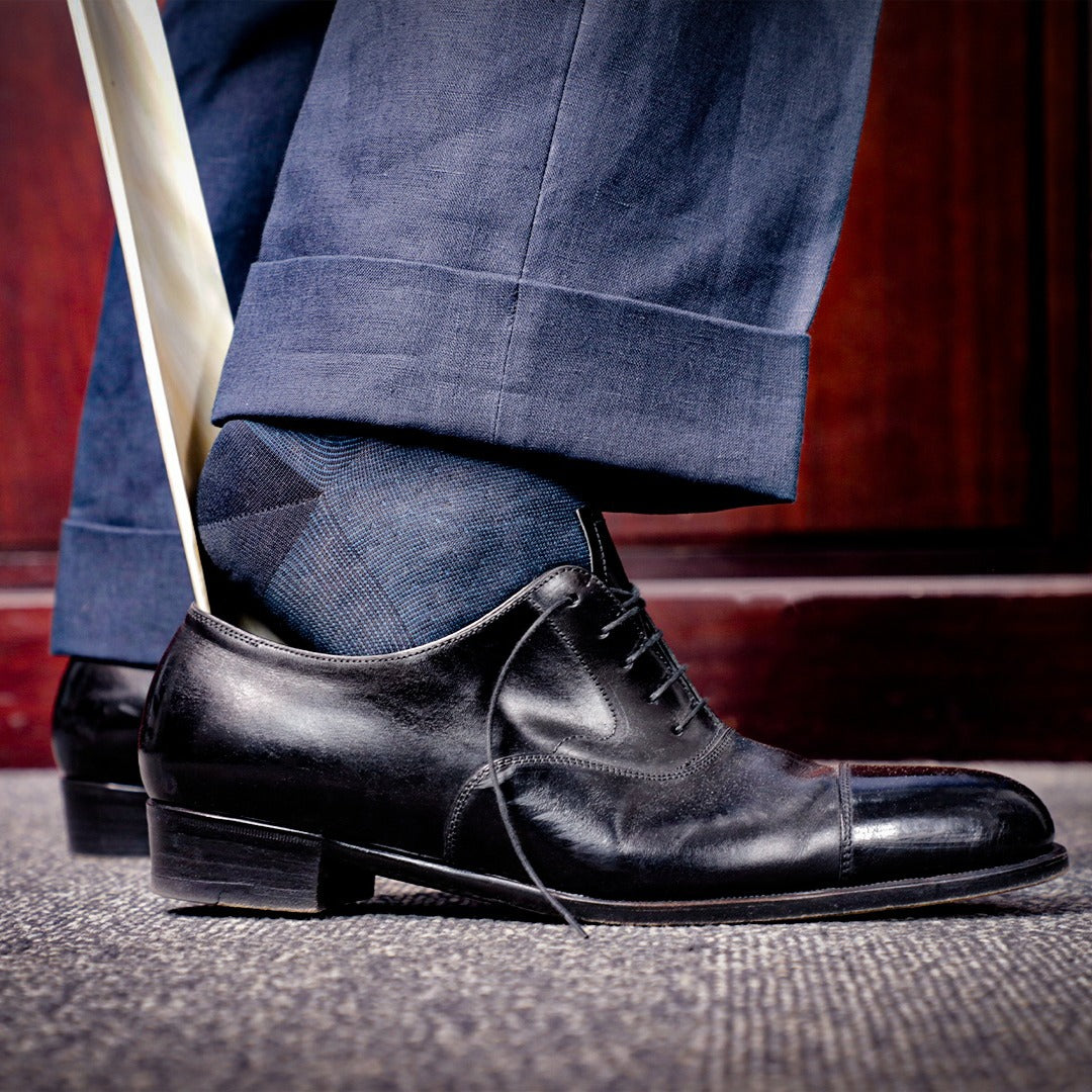 A man's foot is tied to a Wellington Full-Length 24in Mortimer Shoehorn by KirbyAllison.com.